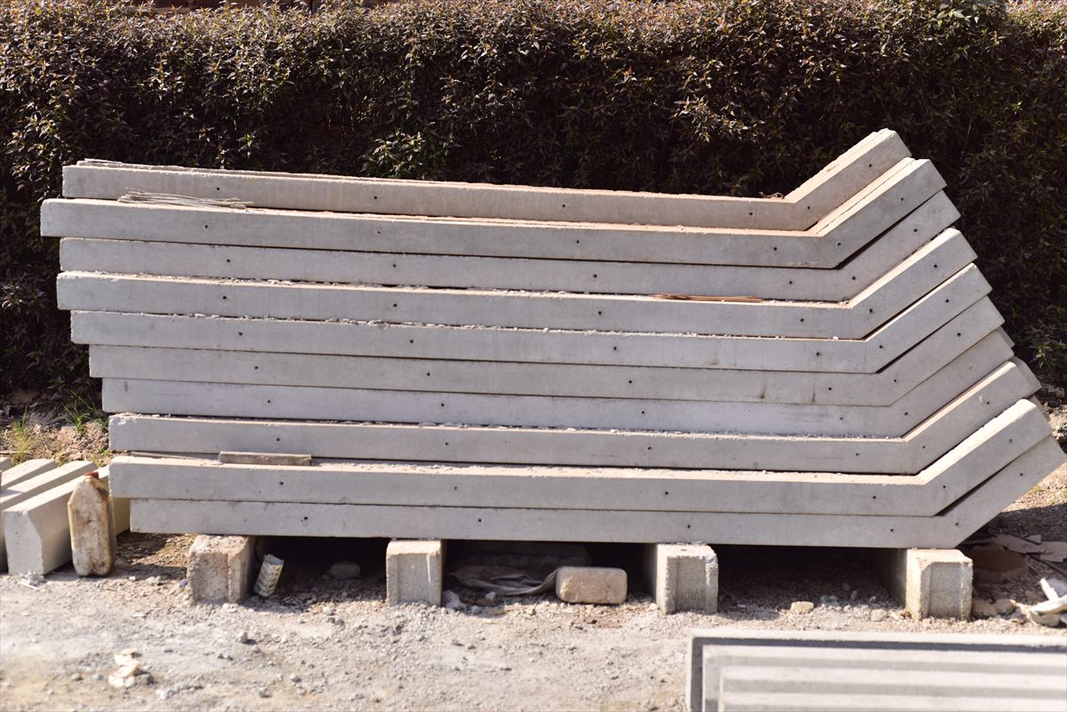 Stack of BOKSWA reinforced concrete fence poles with angled tops and pre-cast wire holes