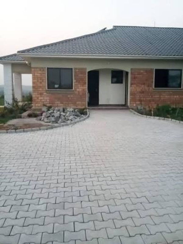 Paved driveway leading to a finished house