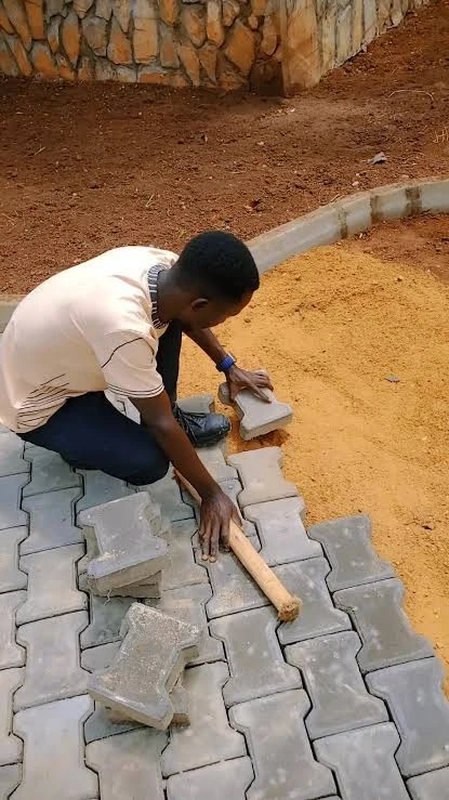 Pavers being laid course by course on a levelled sand bed