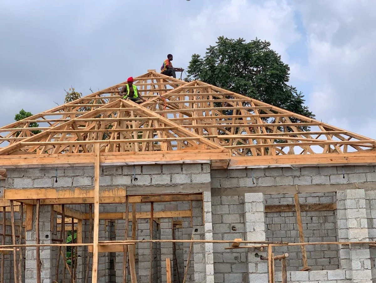 Roof trusses being fixed over completed block walling