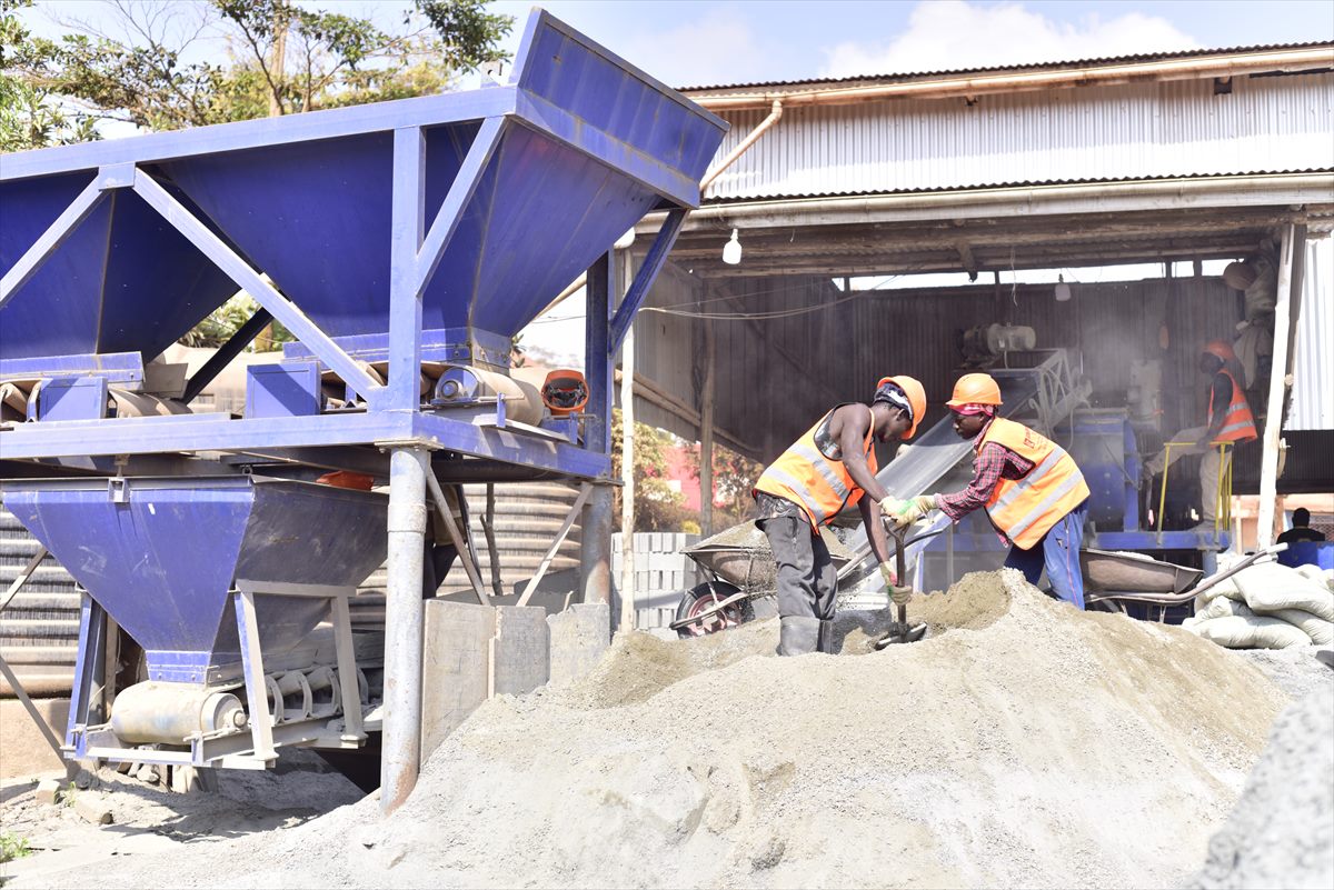 BOKSWA workers in protective equipment feeding the concrete mixer